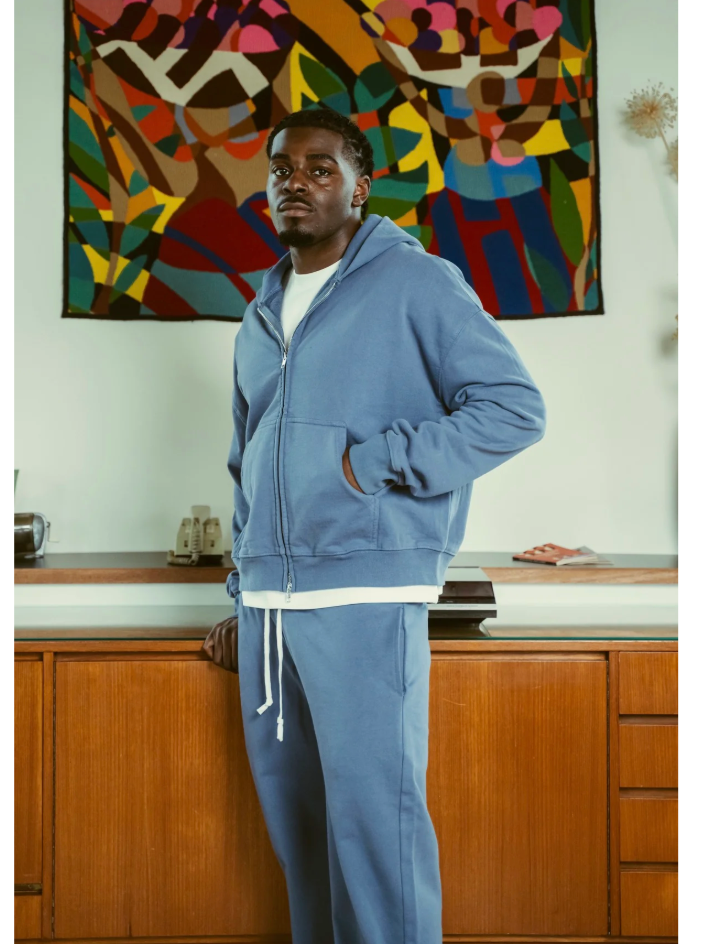 Model wearing a blue BLANCS zip hoodie and matching joggers