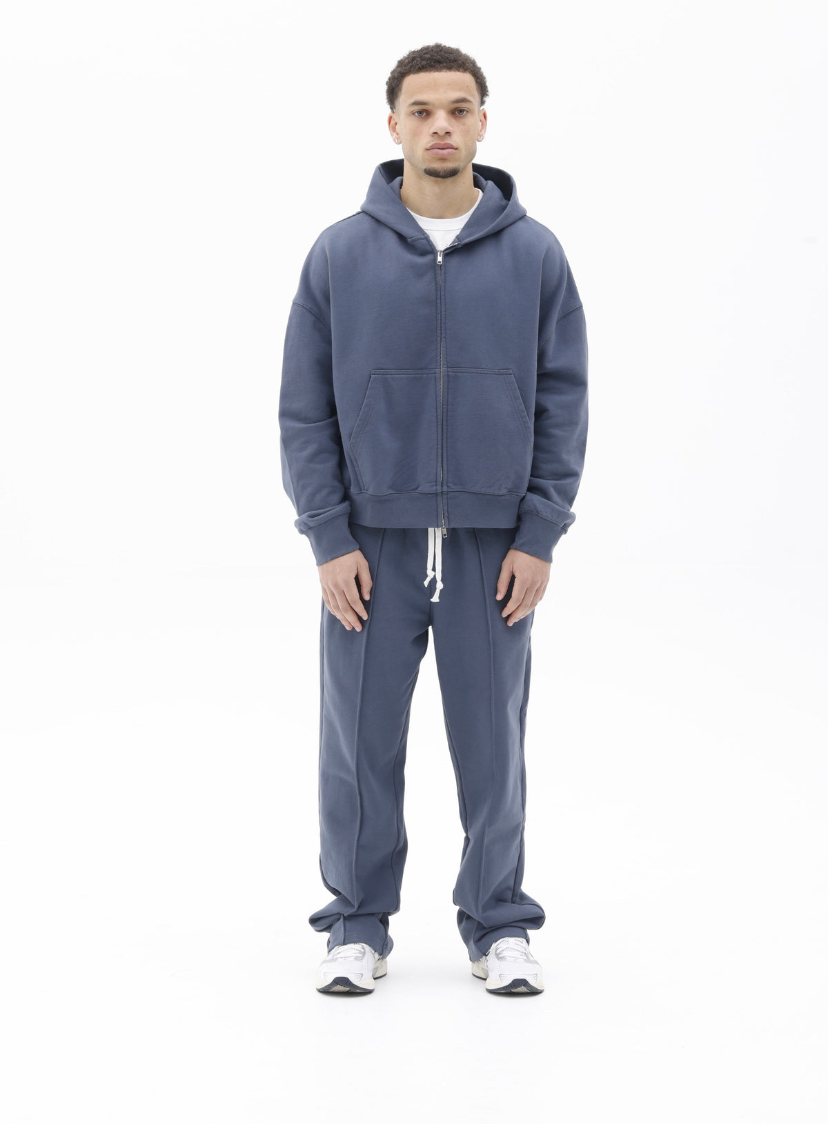 Model wearing a navy BLANCS zip hoodie and matching joggers